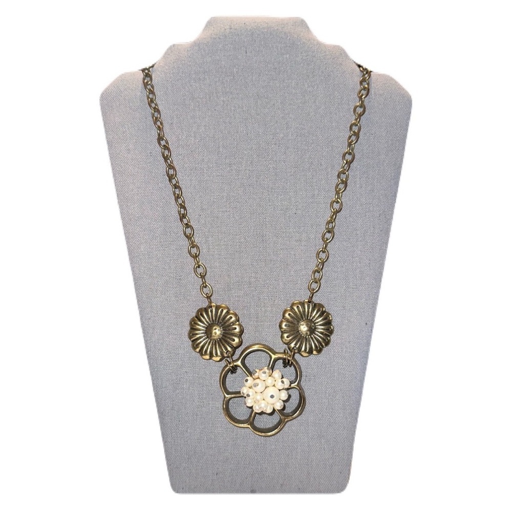 Long statement necklace with brass flower piece featuring faux pearls and brass